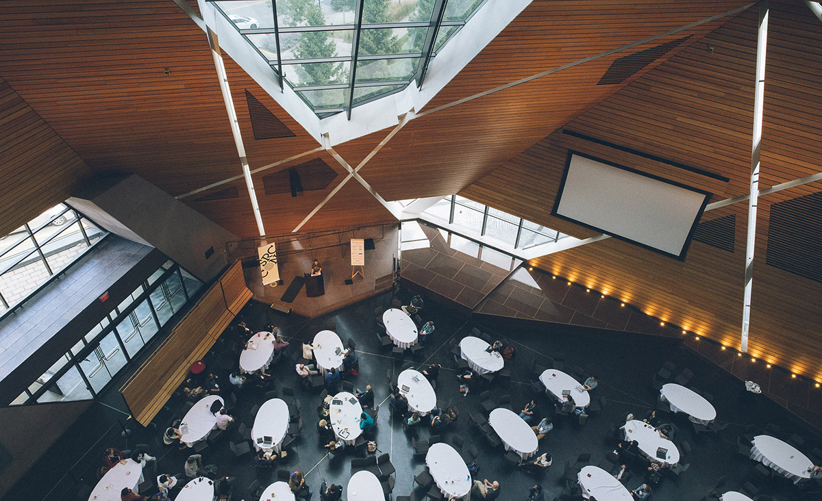 An overhead view in McNamara Alumni Center shows tables full of SRCCON participants.