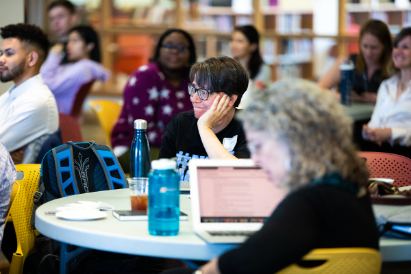 one person listening in focus with a crowd behind